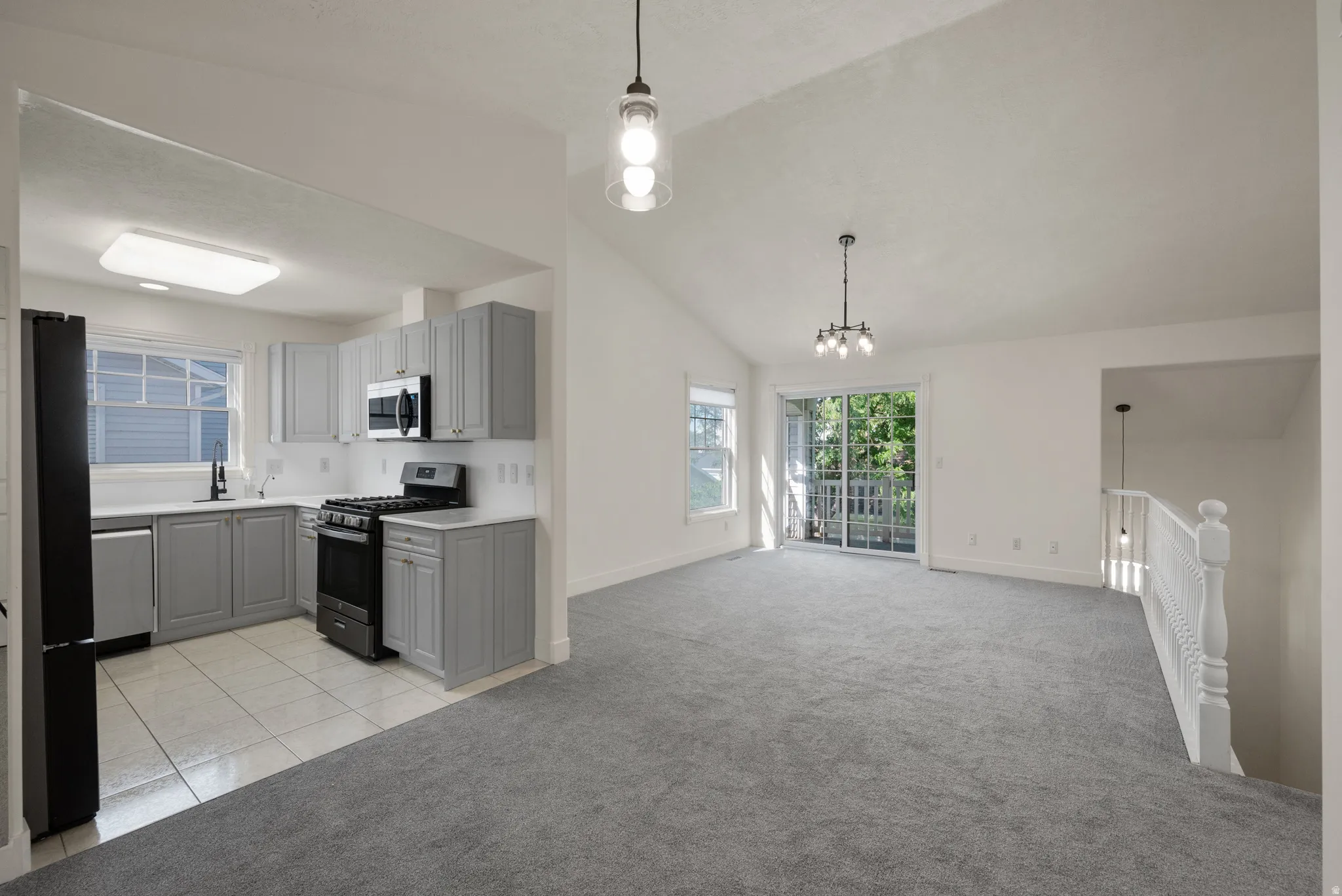 Kitchen with light gray cabinetry, white countertops, and stainless steel appliances