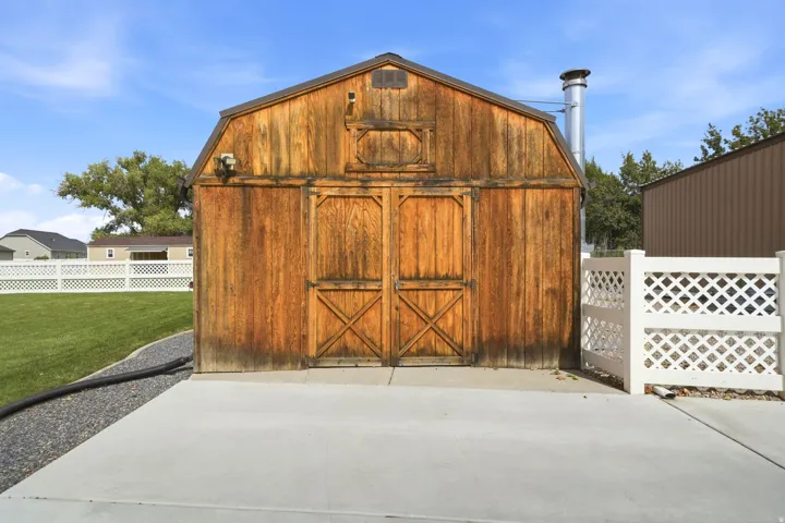 Gable-roofed outbuilding with rustic wood siding and double barn doors