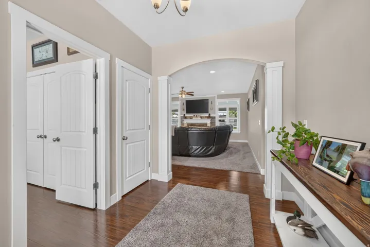 Hardwood-style flooring throughout, white interior doors, arched doorway, and neutral wall tones