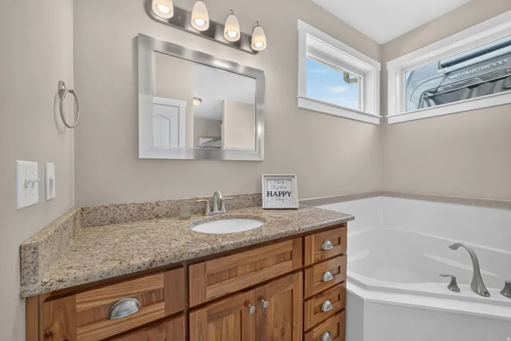Wood-finish vanity with a stone-finish countertop and integrated sink