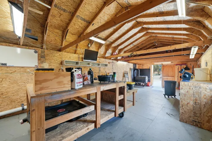 Functional workshop space featuring exposed wood beam ceilings and durable wood-finish walls