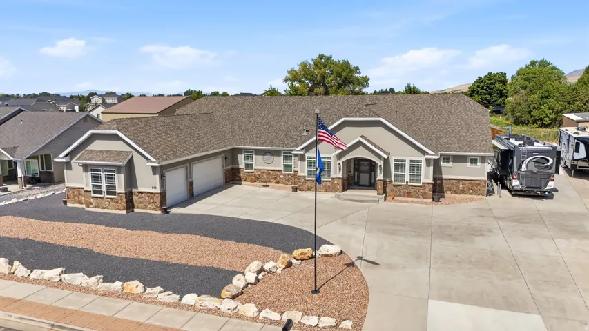 Neutral-toned exterior with stone accents and a multi-car driveway