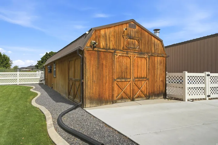 Wooden outbuilding featuring a gambrel roof and double barn doors