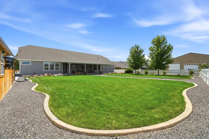 Expansive lawn with defined concrete edging, gravel pathways, and mature trees