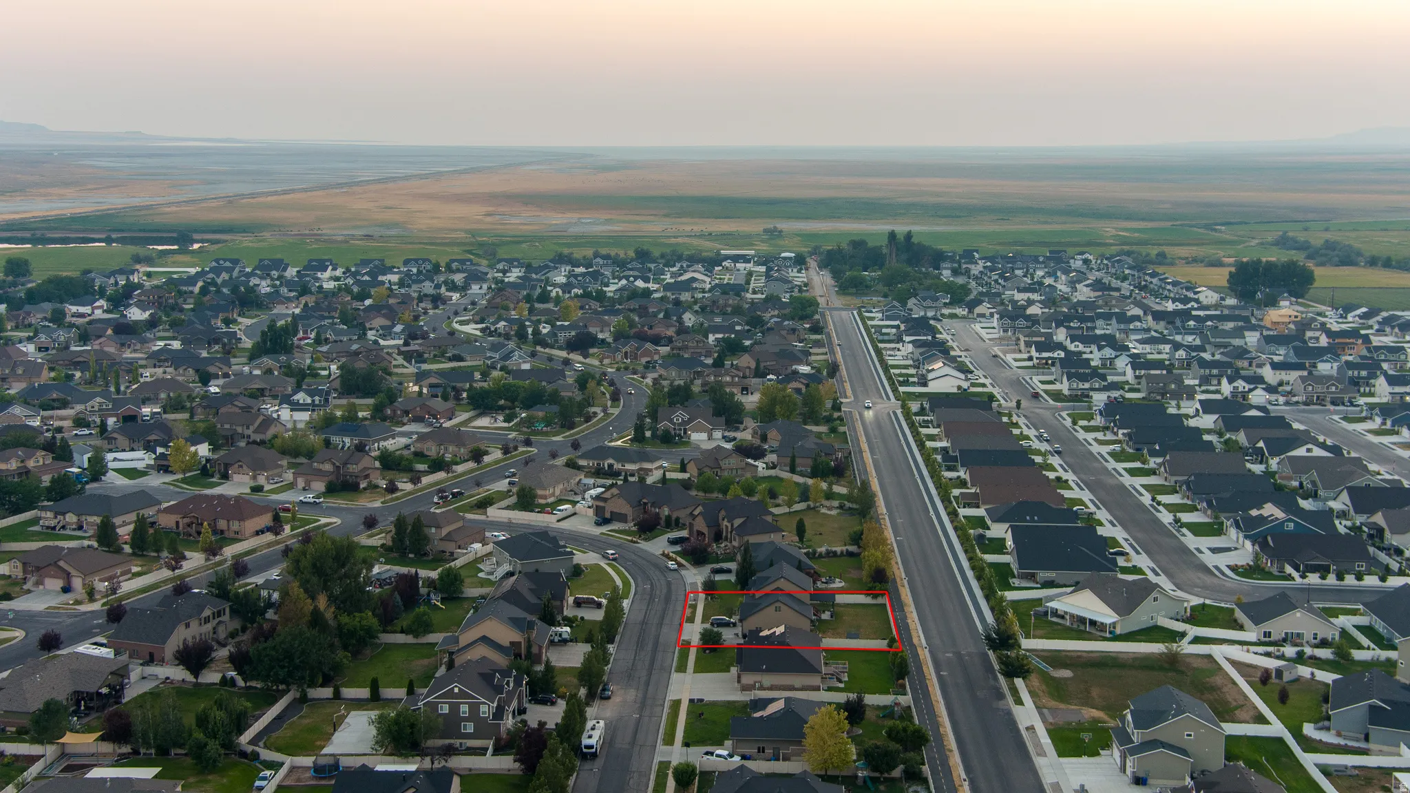 Residential property situated within a developed neighborhood, featuring surrounding open land