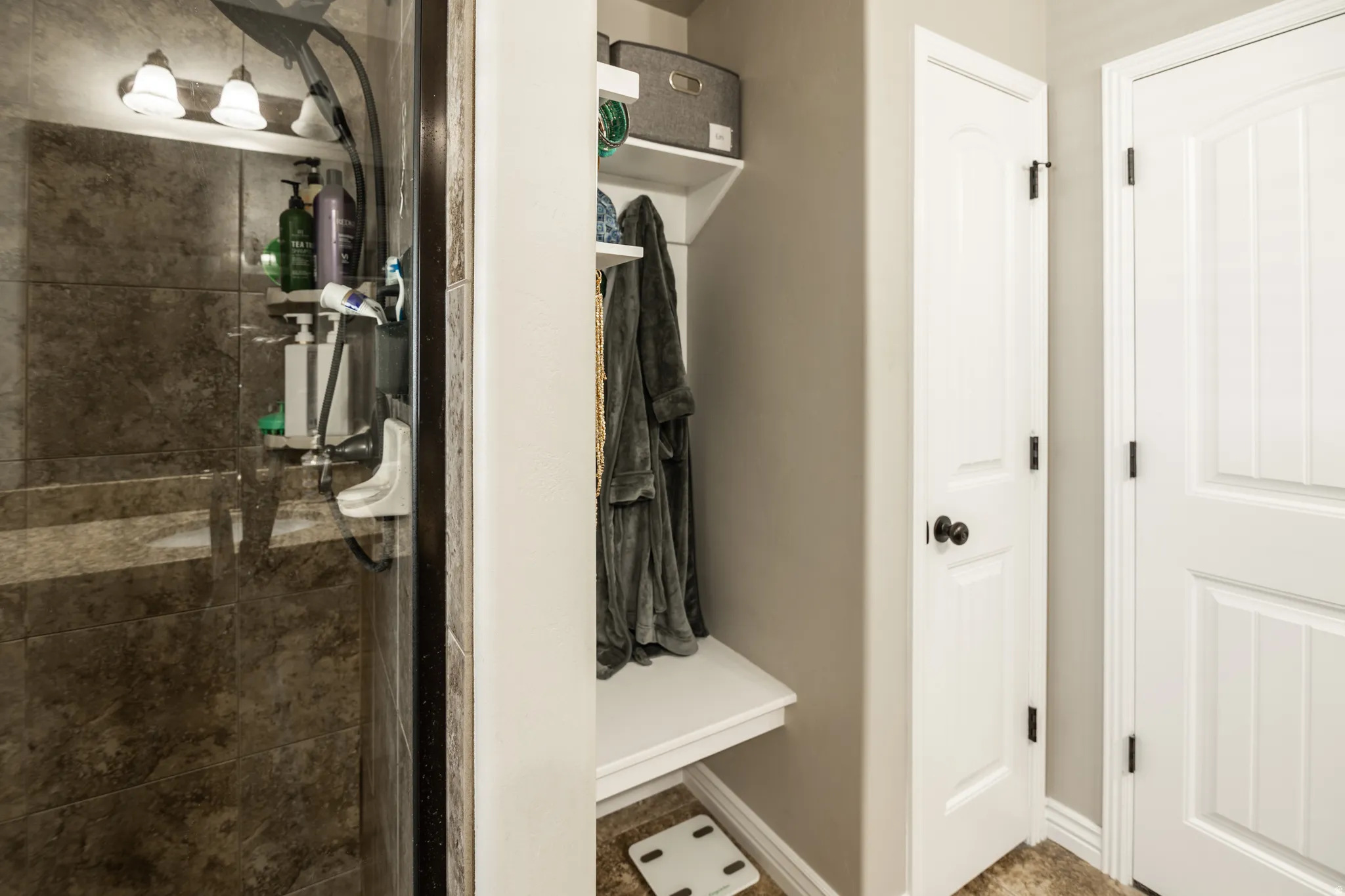 Glass-enclosed shower with stone-look tile surround and built-in bench