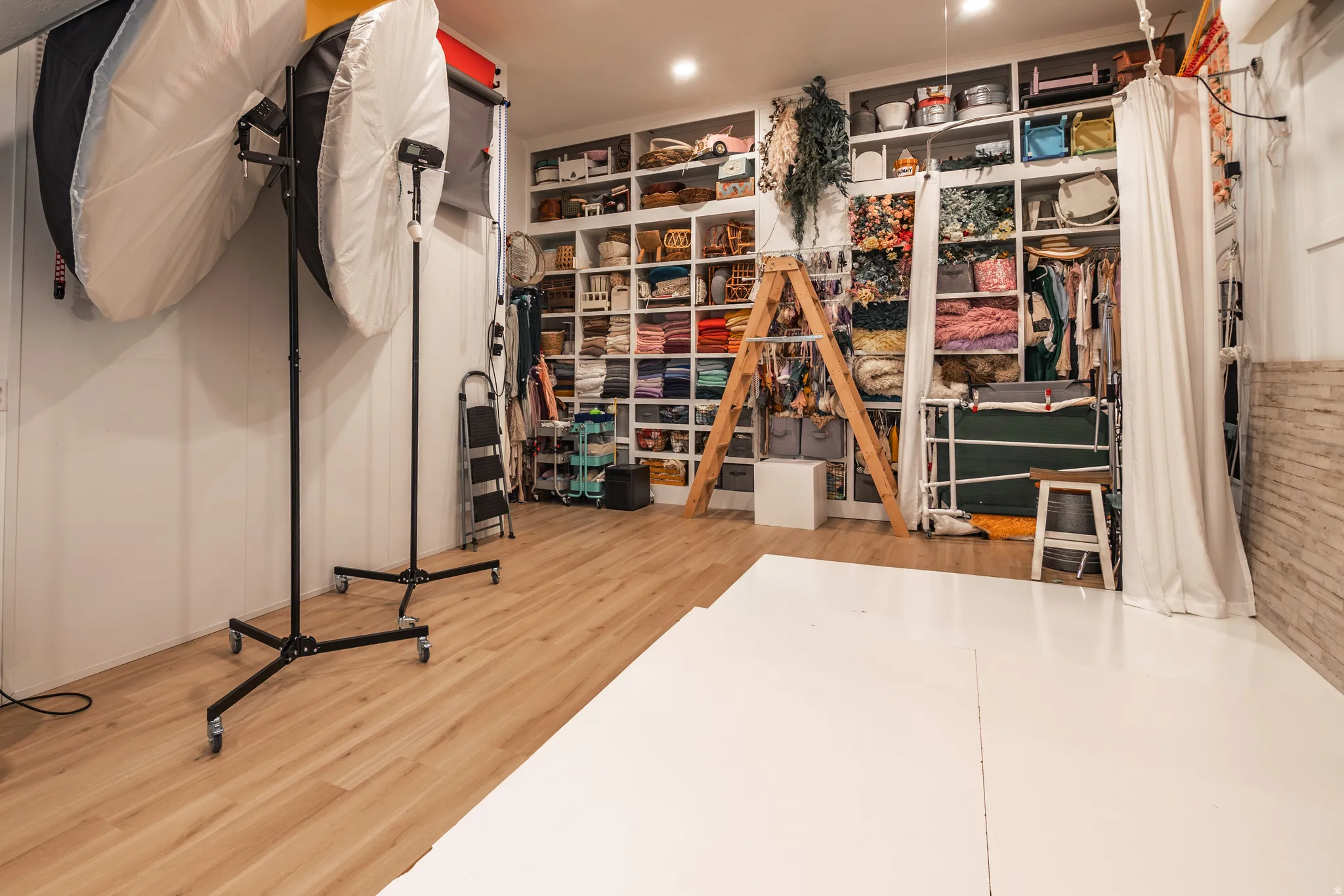 Recessed lighting illuminates the wood-finish flooring and extensive built-in shelving, providing abundant storage