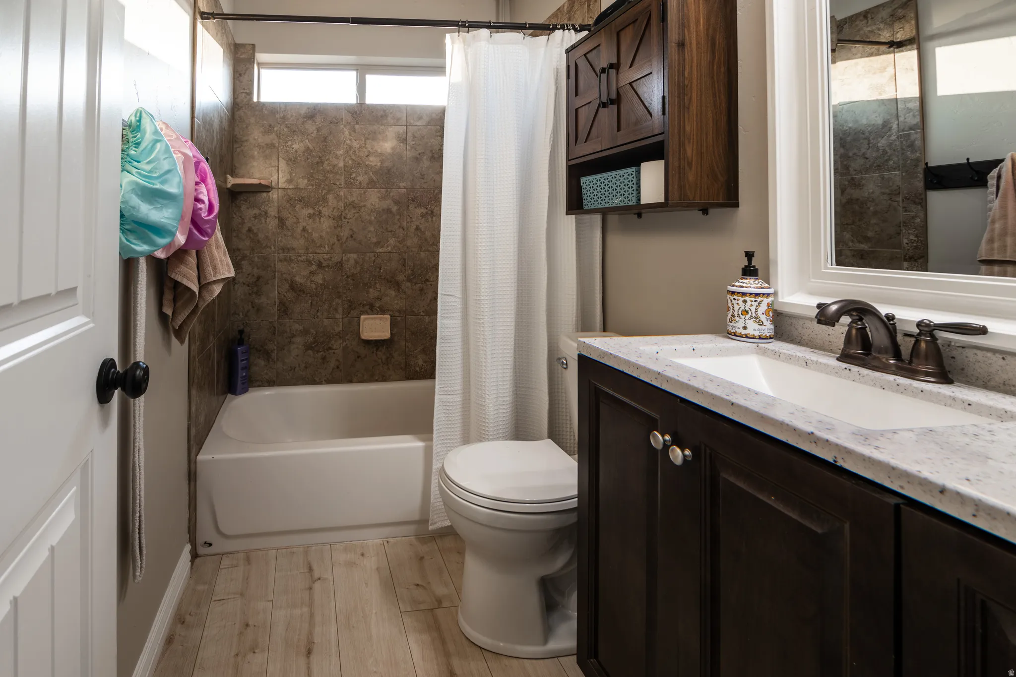 Bathroom featuring a dark wood finish vanity with a light-colored countertop and an undermount sink