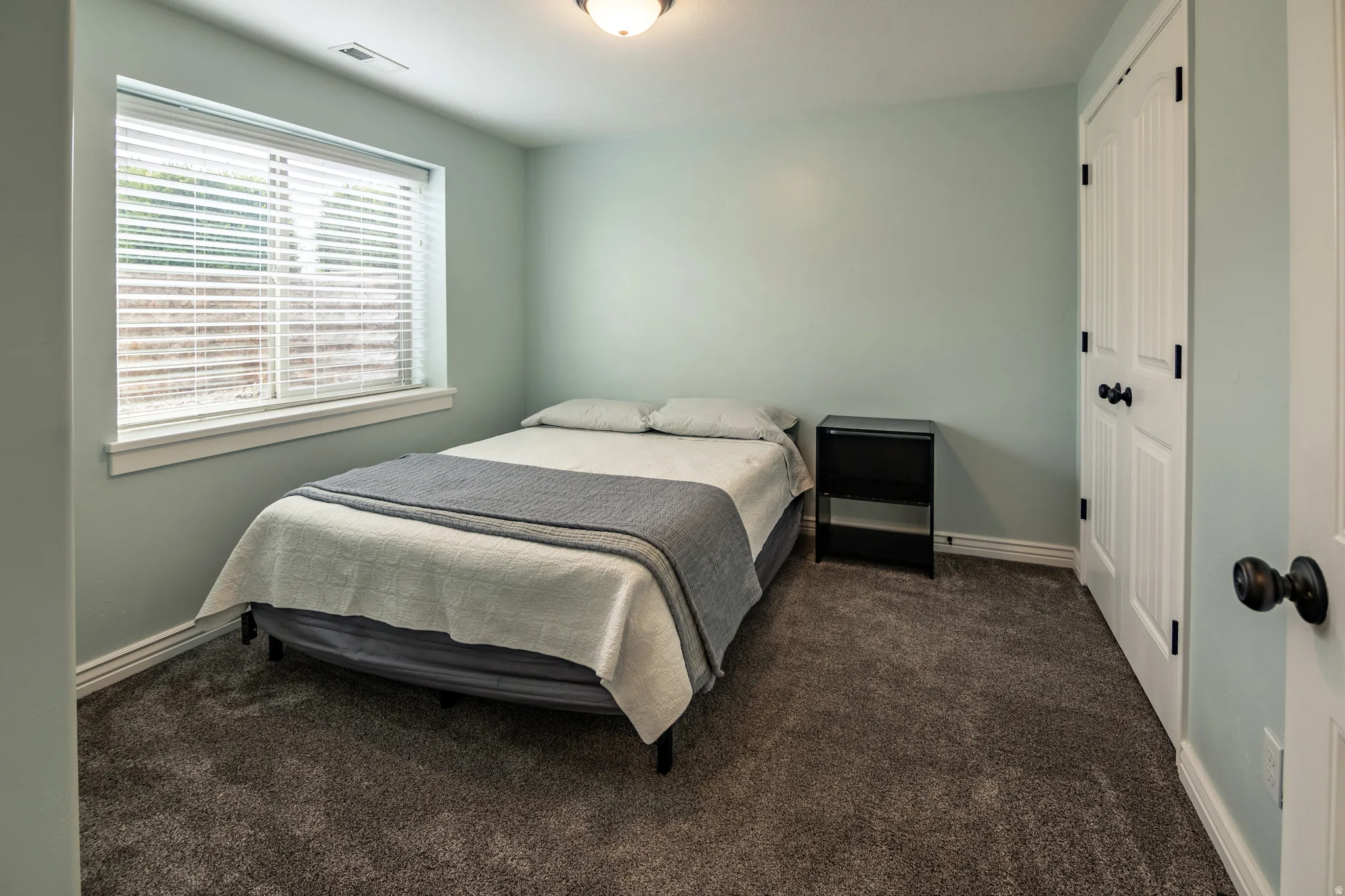 Wall-to-wall carpeting, recessed window with blinds, and white trim throughout