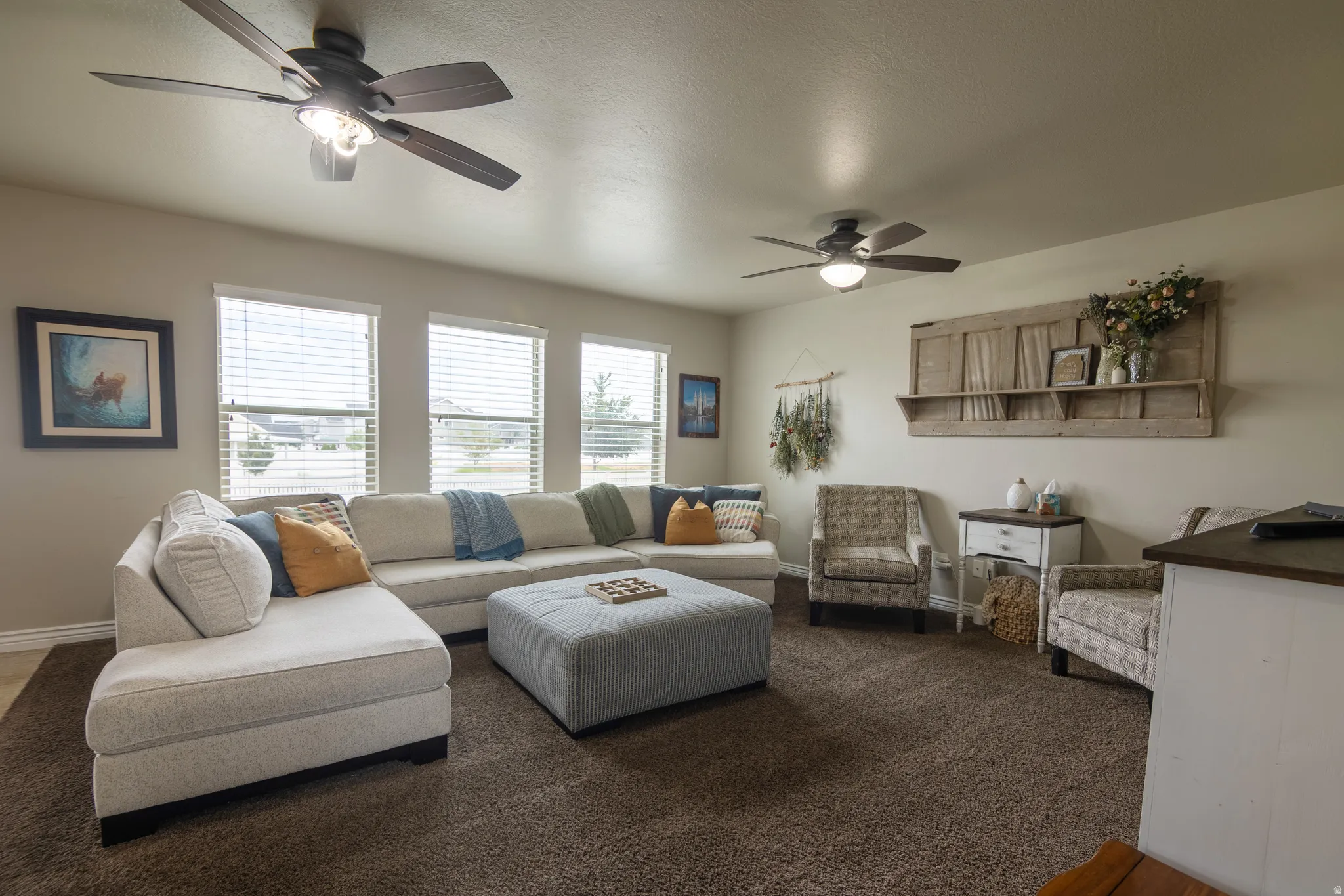 Recessed lighting, multiple windows with blinds, two ceiling fans with integrated lighting, and carpeted flooring