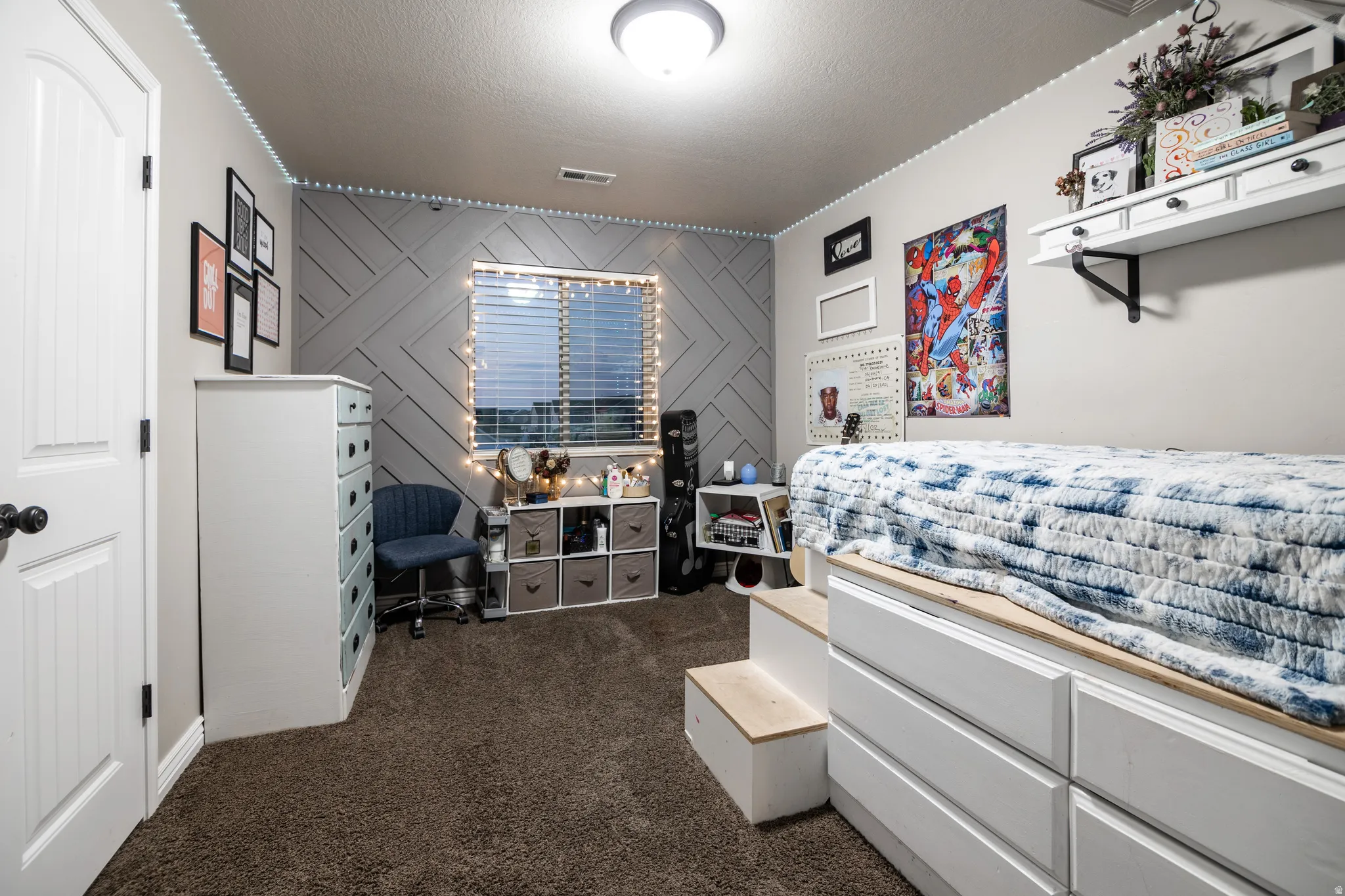 Accent wall with geometric paneling, carpeted flooring, window with blinds, and flush-mount ceiling light