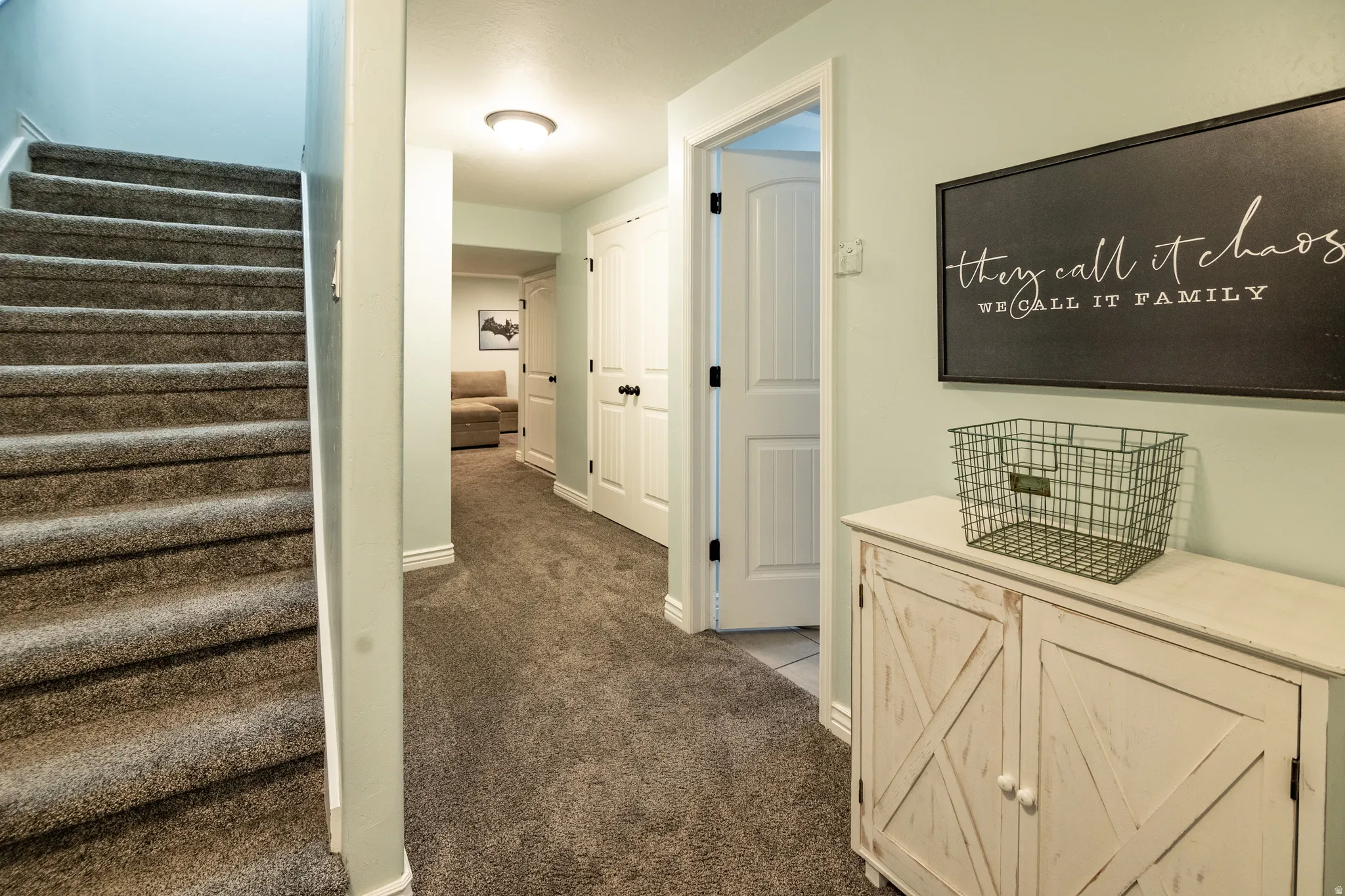 Carpeted staircase with light-colored walls, white trim, and white paneled doors