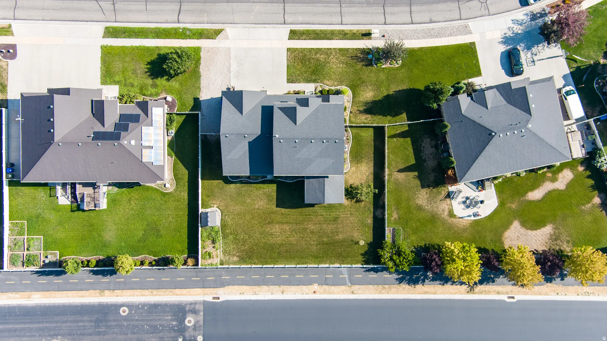 Paved street frontage, extensive green lawns, and a concrete driveway