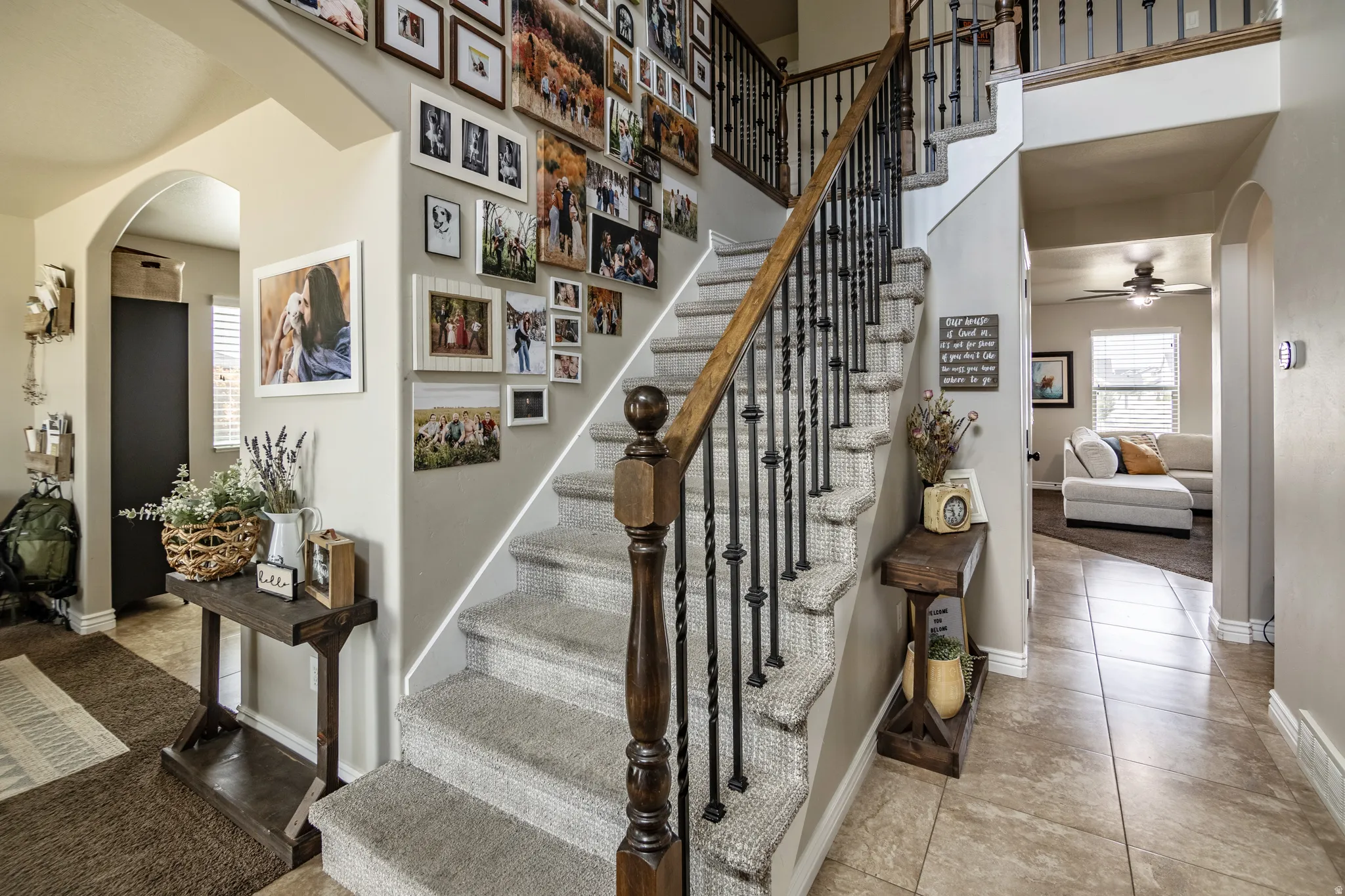 Staircase with carpeted treads and wrought iron balusters