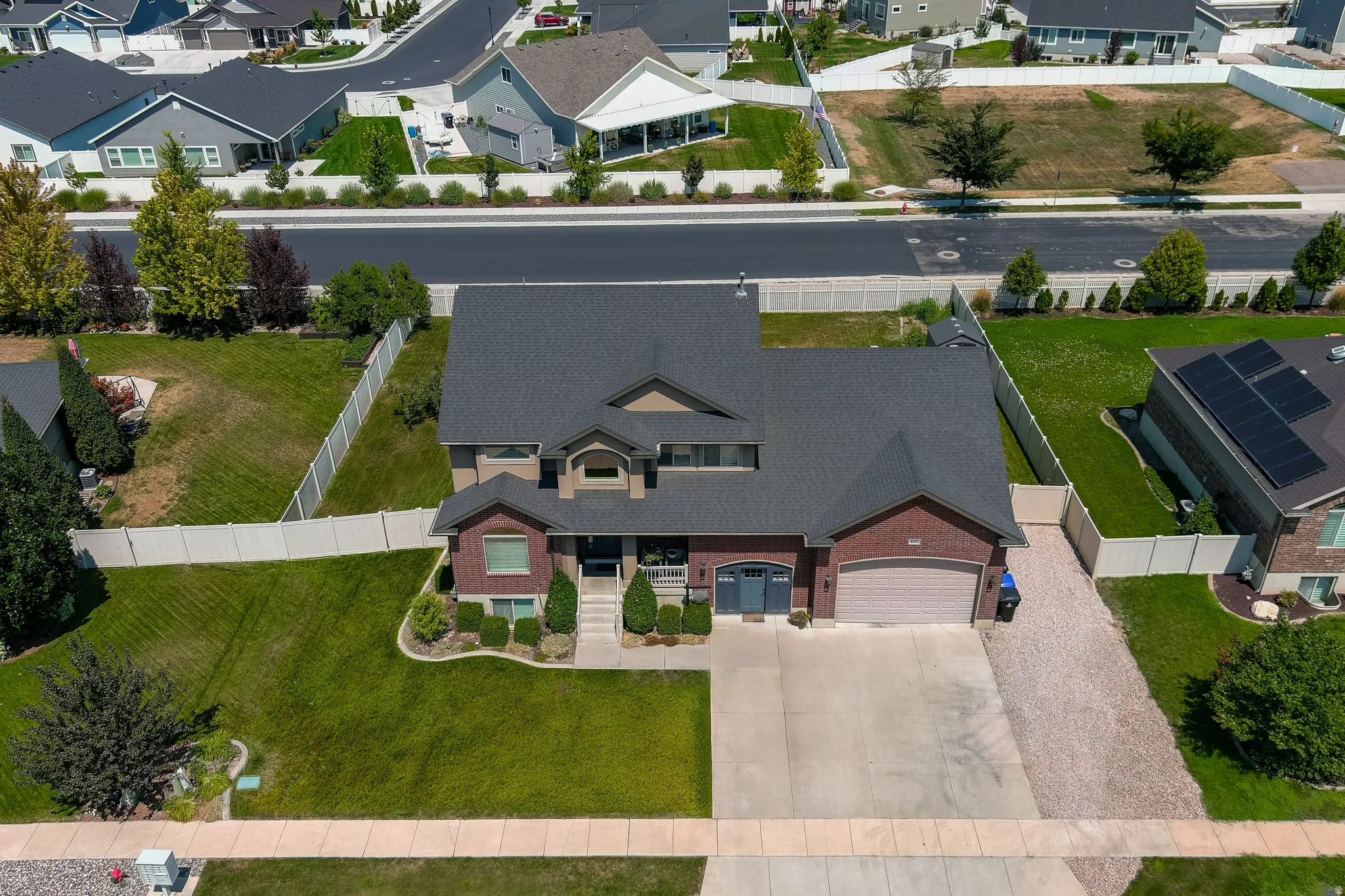 Brick exterior with a dark shingle roof, concrete driveway, and attached garage