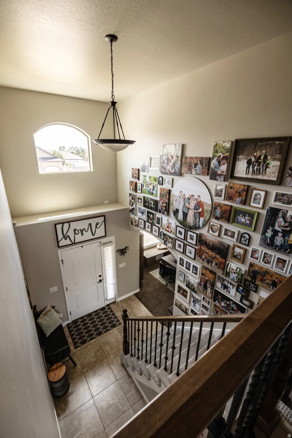 Two-story foyer with a vaulted ceiling, arched window, and tiled flooring