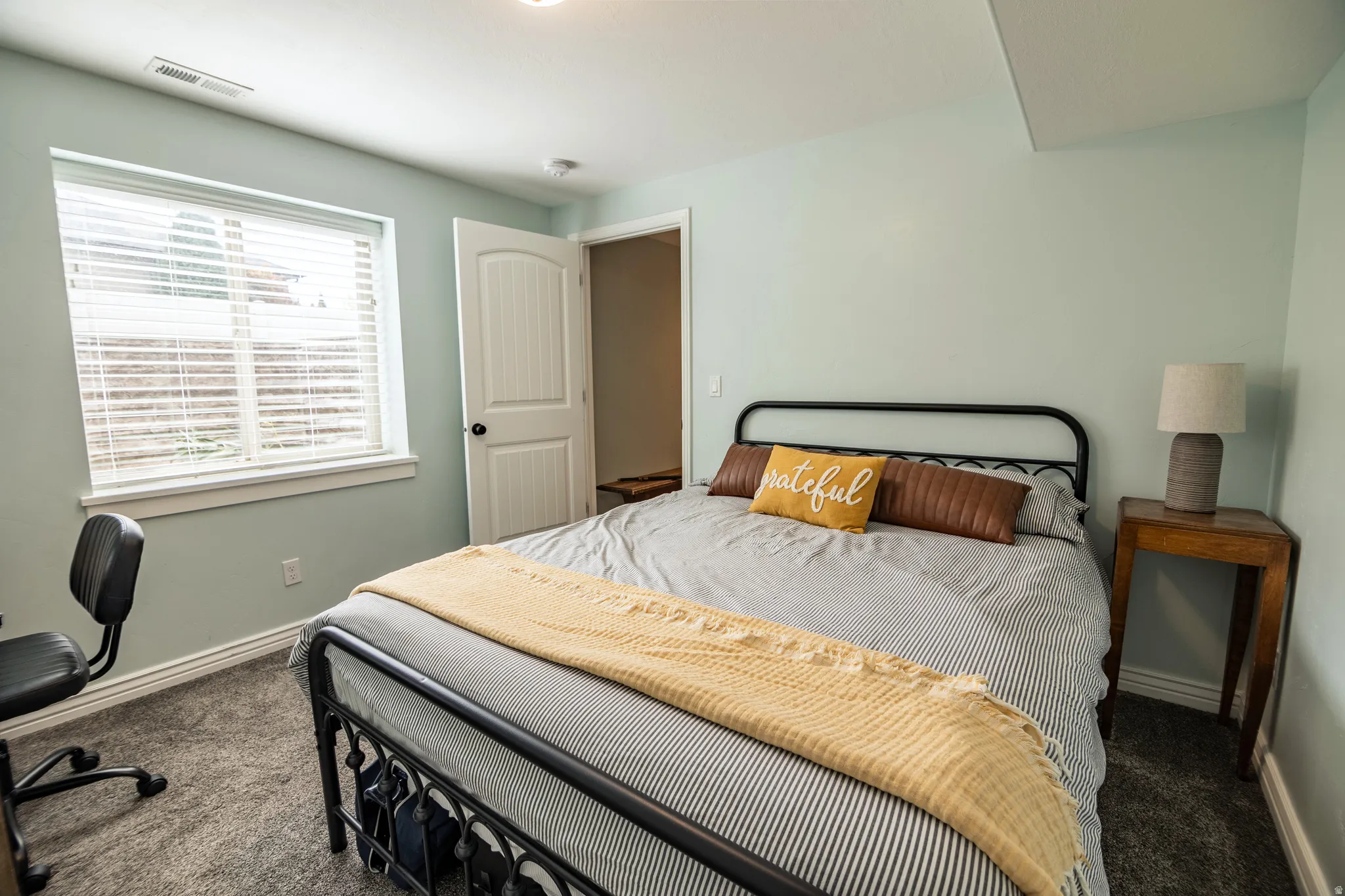 Wall-to-wall carpeted flooring, single window with blinds, white trim, and a paneled door