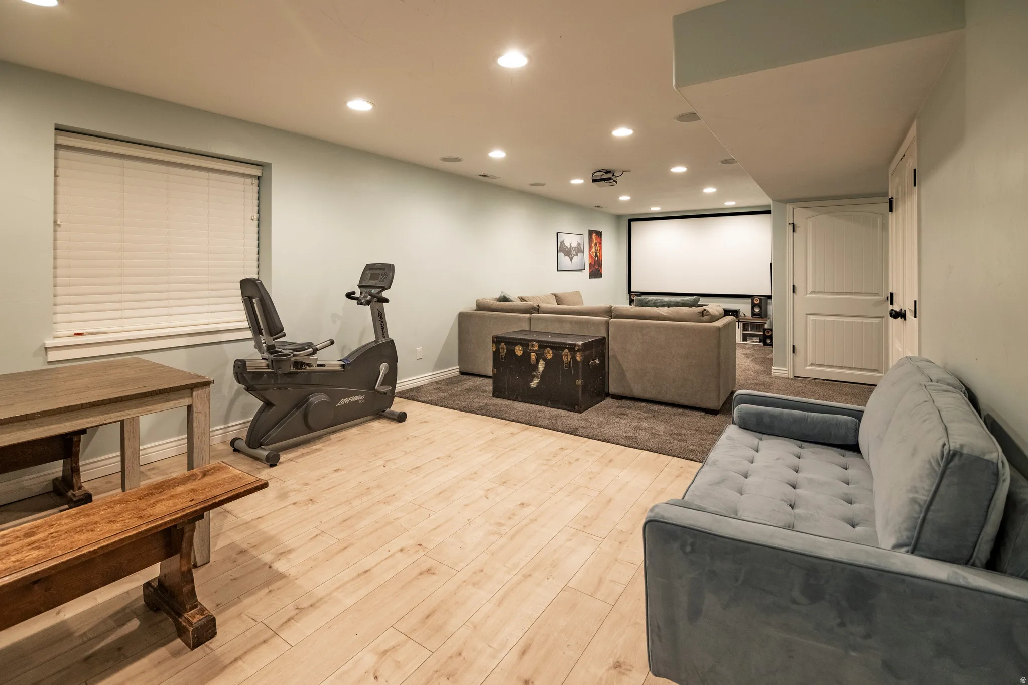 Recessed lighting, wood-finish flooring, projector screen, and a built-in projector