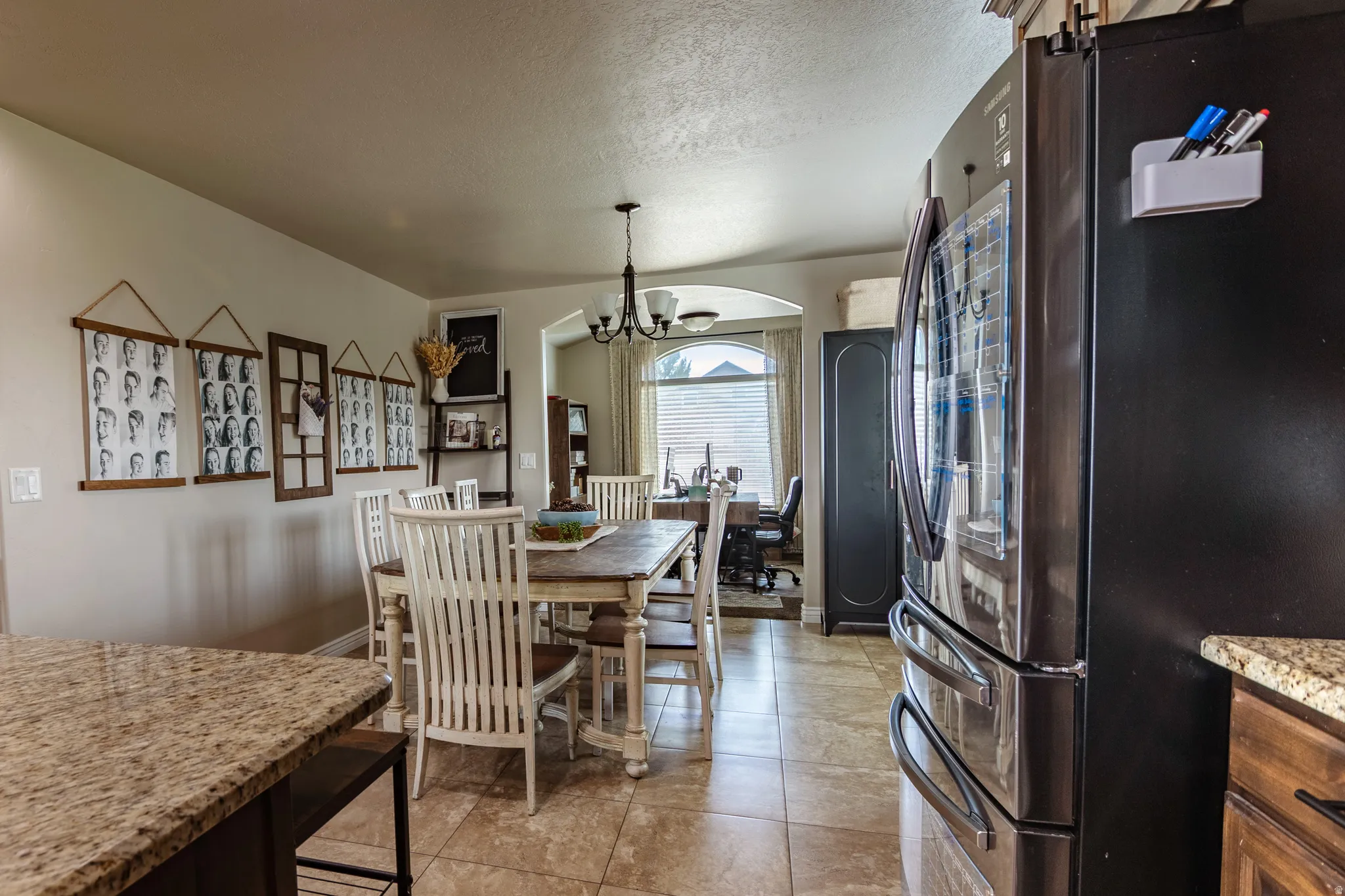 Tile flooring with a light grout, archway entry, and a built-in arch window with horizontal blinds