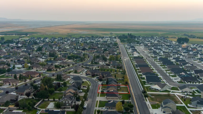 Residential property situated within a developed neighborhood, featuring surrounding open land