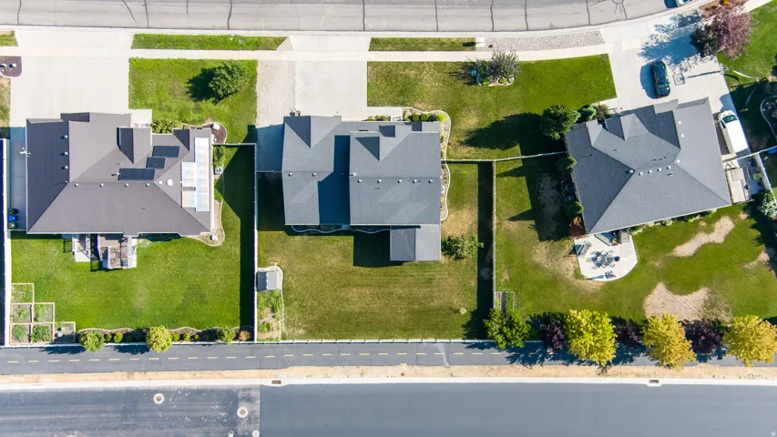 Paved street frontage, extensive green lawns, and a concrete driveway