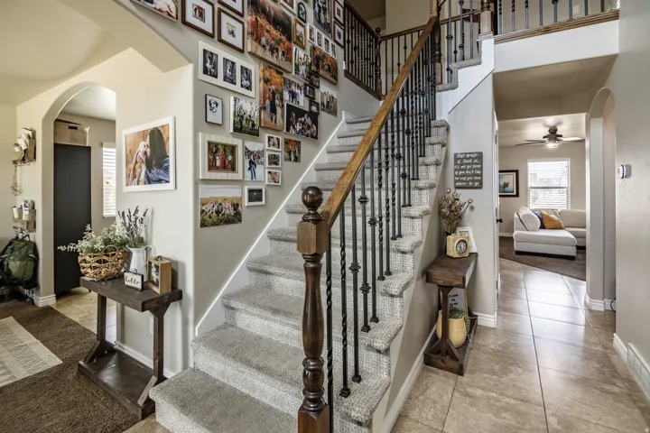 Staircase with carpeted treads and wrought iron balusters