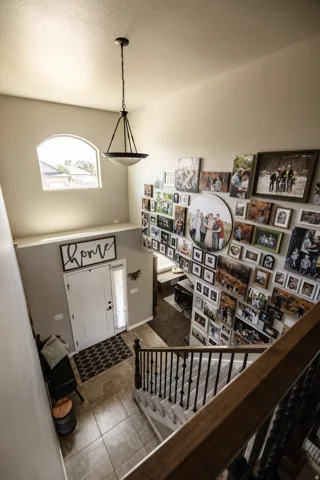 Two-story foyer with a vaulted ceiling, arched window, and tiled flooring