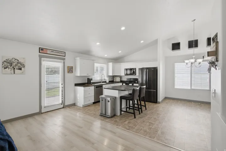 Kitchen with white cabinetry, black countertops, and stainless steel appliances