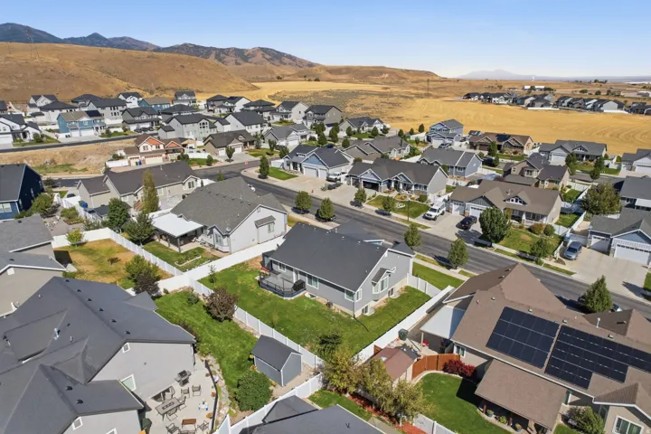 Residential street with varied architectural styles, individual garages, and fenced backyards