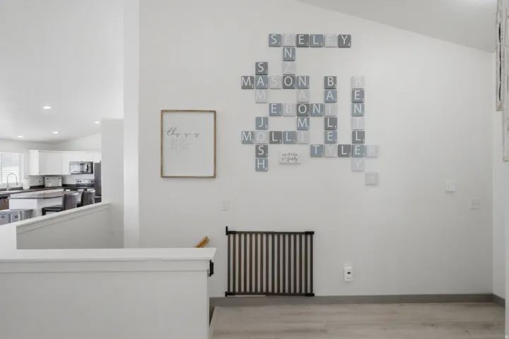 Vaulted ceiling, recessed lighting, wood-finish flooring, white wall paint, open-concept design