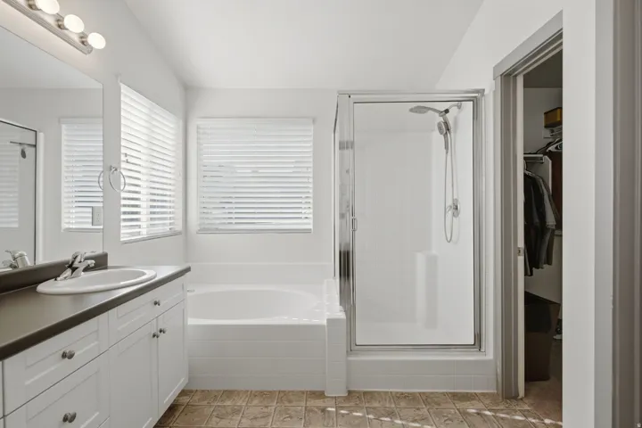 White vanity with a single sink, an attached mirror, and built-in cabinetry