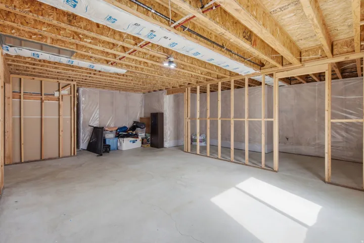 Expansive unfinished lower level featuring exposed wood joists and structural framing