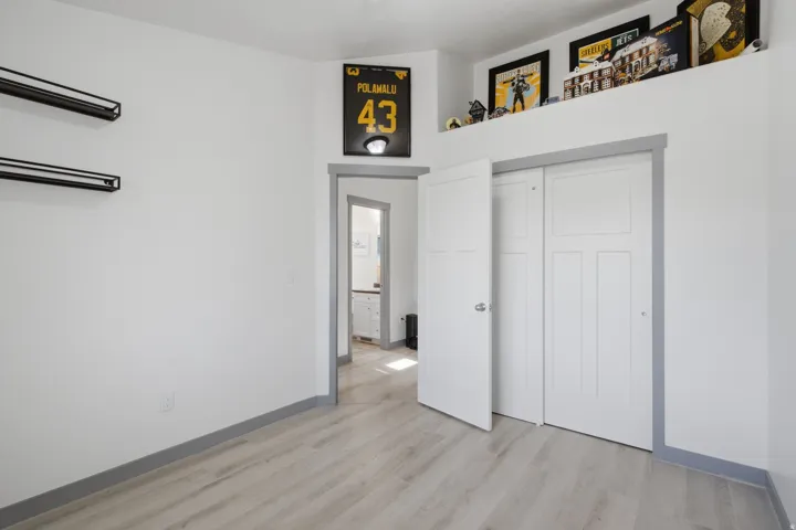 Light wood-finish flooring, white walls, and gray trim