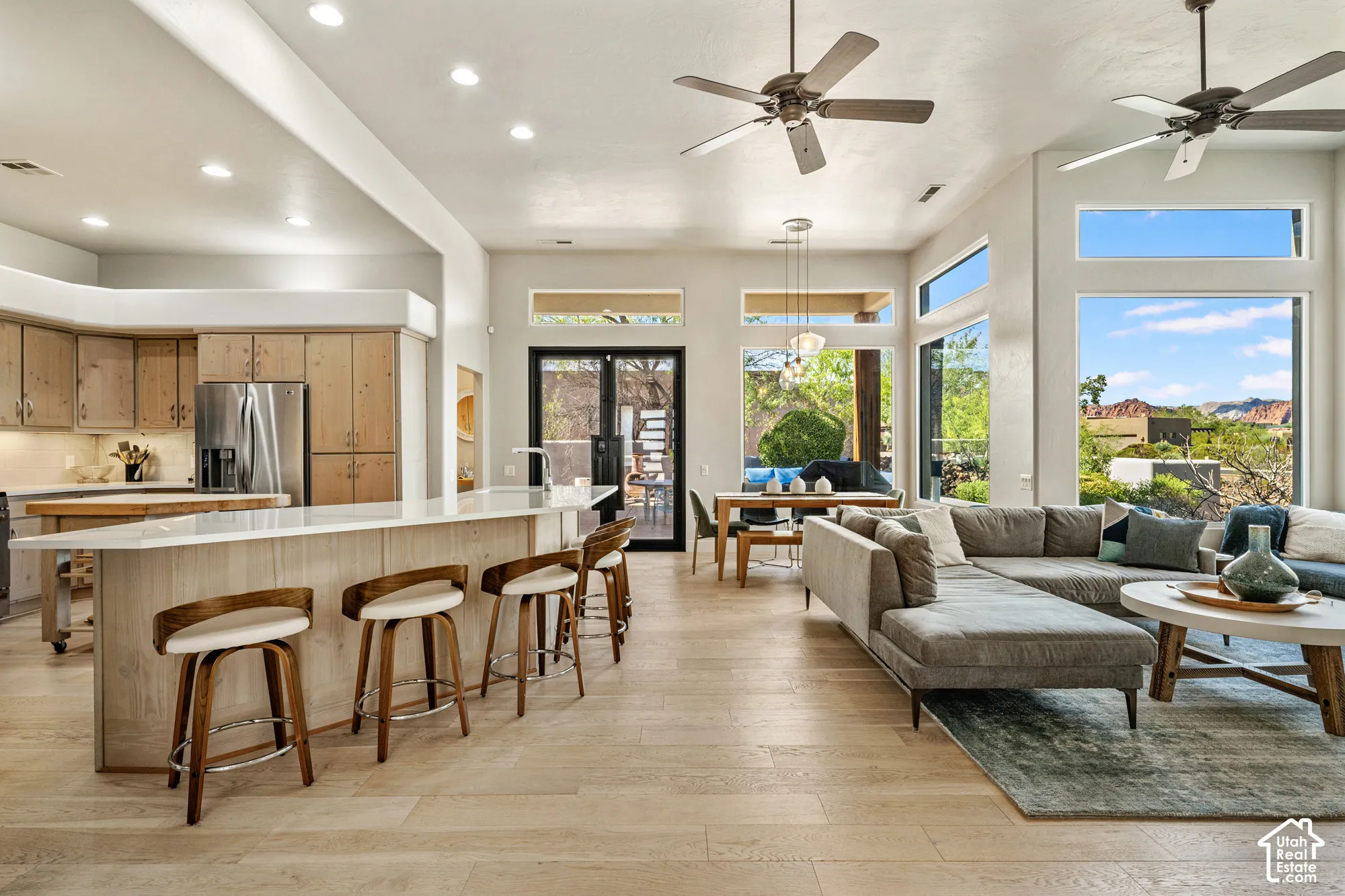 Open concept living area with high ceilings, recessed lighting, and wood-finish flooring