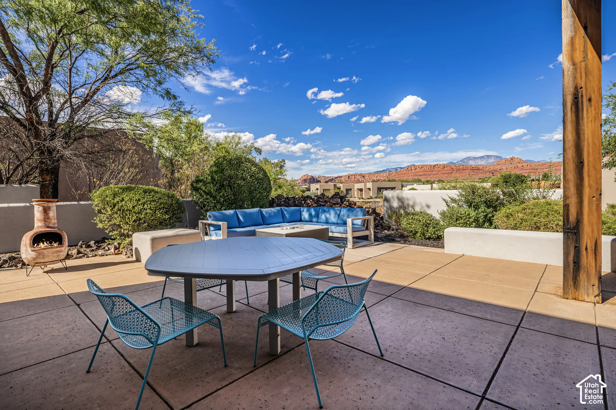 Expansive outdoor patio featuring concrete pavers, built-in seating, a fire pit, and a chiminea