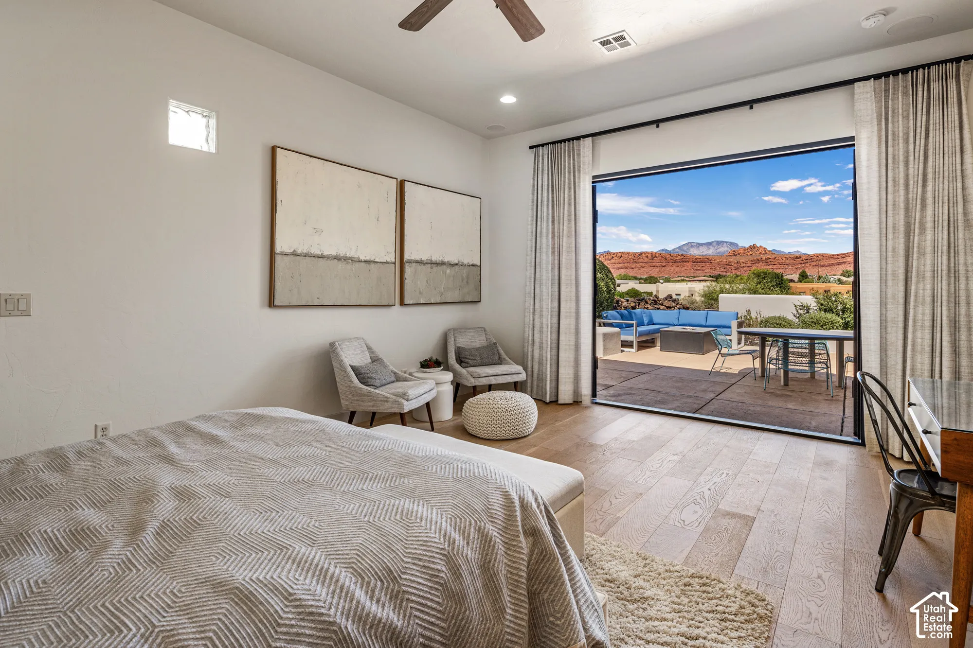 Expansive sliding glass doors, wood-finish flooring, recessed lighting, and a ceiling fan