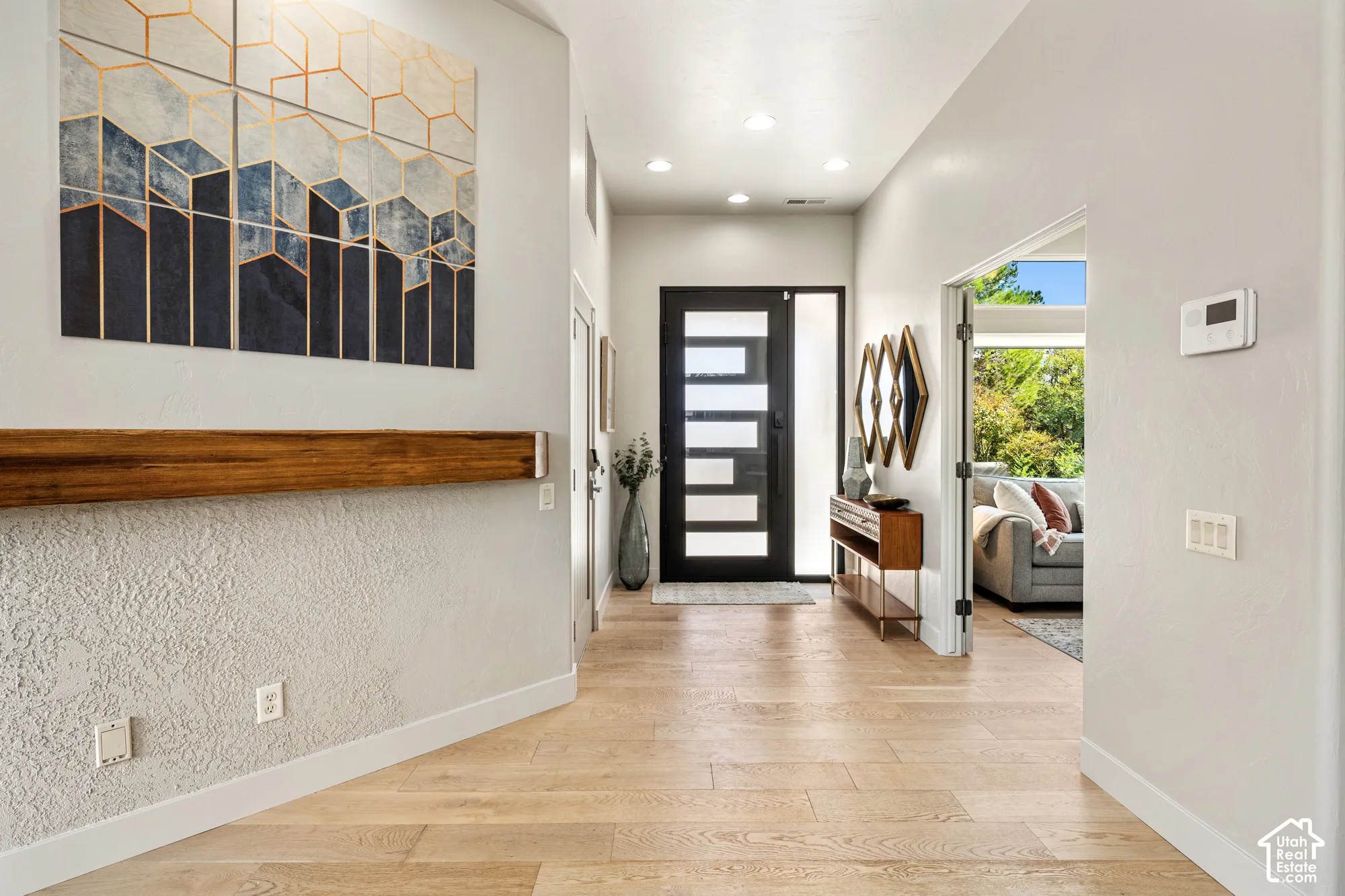 Light wood-finish flooring extending through the entry