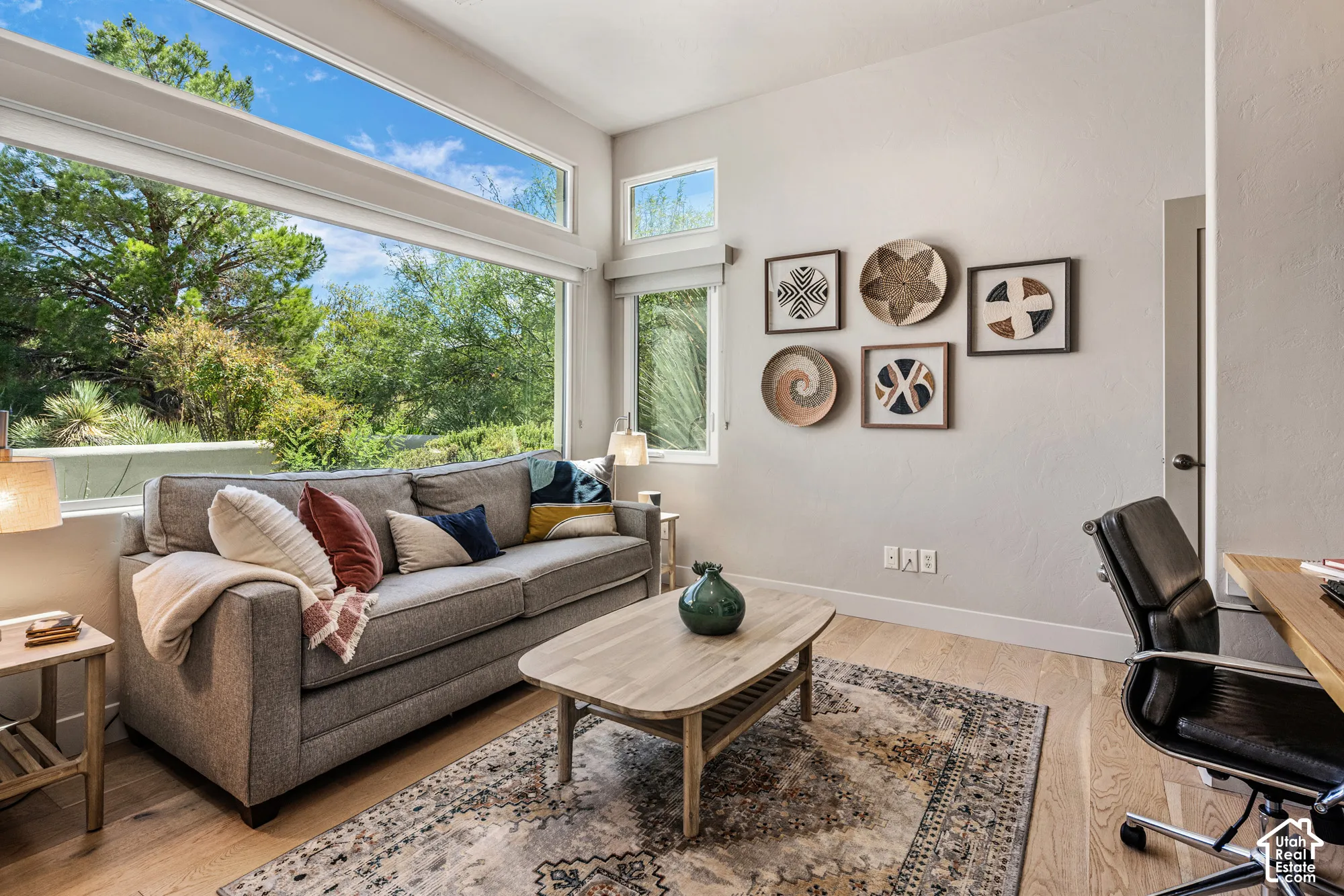 Expansive window wall with transom windows, light wood-finish flooring, and recessed lighting
