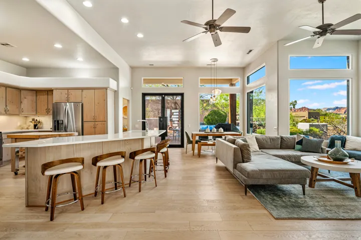 Open concept living area with high ceilings, recessed lighting, and wood-finish flooring
