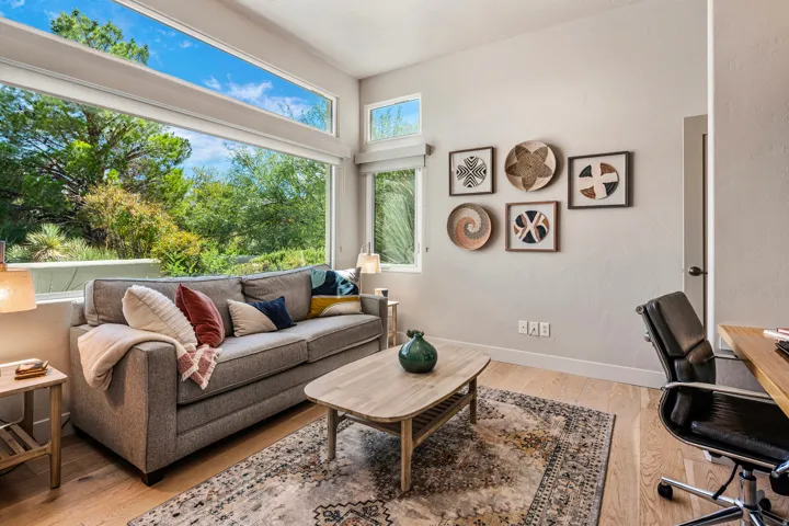 Expansive window wall with transom windows, light wood-finish flooring, and recessed lighting