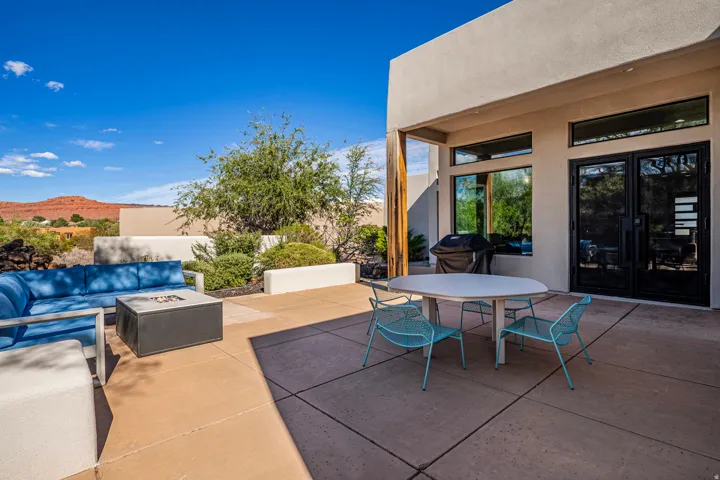 Expansive outdoor patio with concrete paving, a built-in planter, and a prominent mountain backdrop