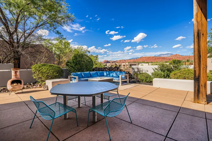 Expansive outdoor patio featuring concrete pavers, built-in seating, a fire pit, and a chiminea