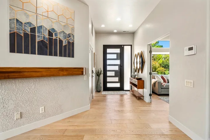Light wood-finish flooring extending through the entry