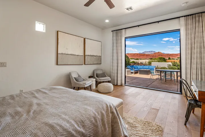 Expansive sliding glass doors, wood-finish flooring, recessed lighting, and a ceiling fan