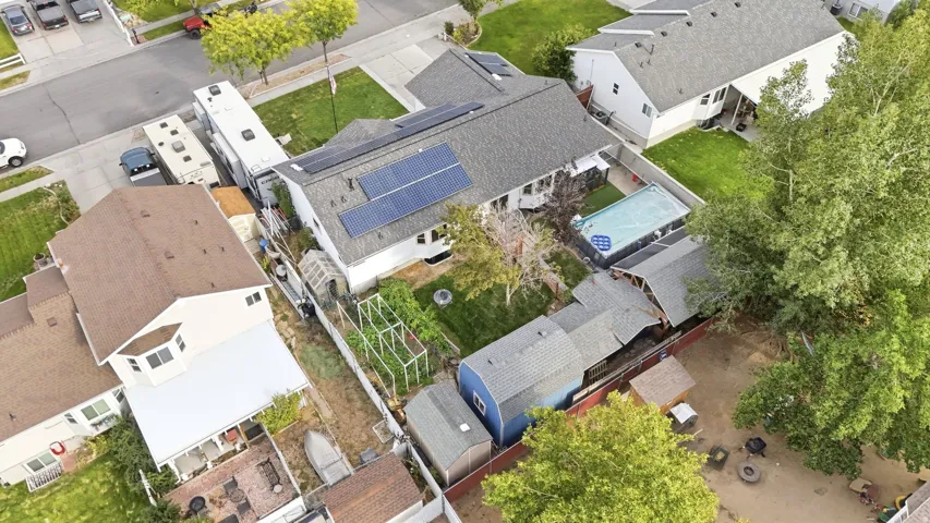 Rooftop solar panels, a fenced backyard, an above-ground pool, and multiple storage sheds