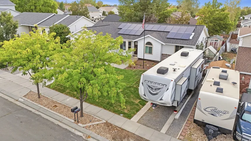Ranch-style exterior with solar panels, mature landscaping, and dedicated RV parking