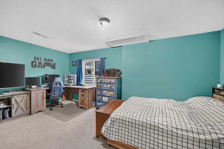 Carpeted flooring, corner desk, and ceiling-mounted light fixture