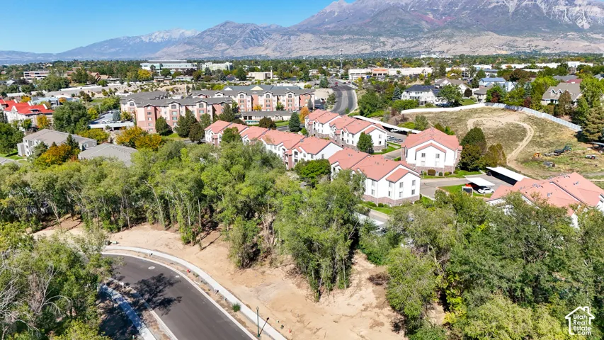 Community setting with residential buildings, surrounding trees, and distant mountains