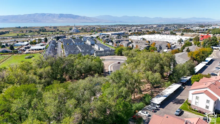 Aerial perspective capturing a distant body of water, mountain range, and surrounding urban landscape
