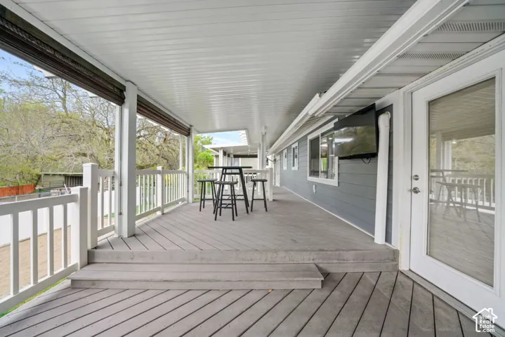 Balcony / Expansive covered deck featuring shades